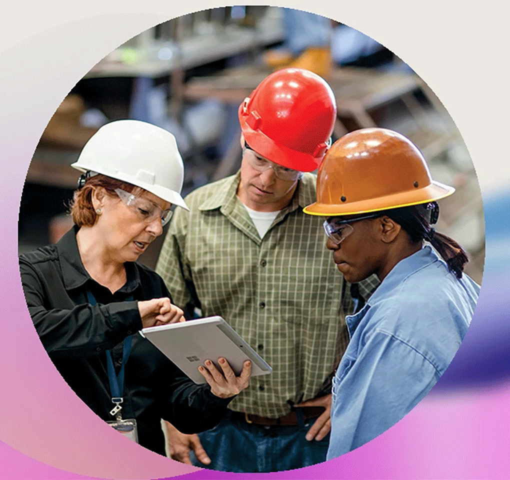 Three people wearing hardhats, one using a tablet device to show them something